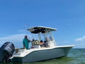 Two anglers enjoy a fishing trip aboard a Key West boat, showcasing the excitement of on-water activities in a beautiful setting.
