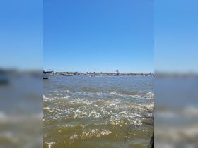 A view of boats on the water under a clear blue sky, but the image lacks clarity and detail.