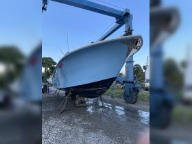 A striking view of a boat on a lift at the dock, showcasing its sleek design and vibrant color — perfect for fishing enthusiasts and boat lovers.