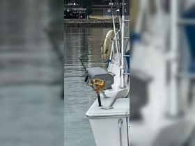 A close-up view of fishing gear mounted on the side of a boat, showcasing the essential equipment for a successful fishing trip.
