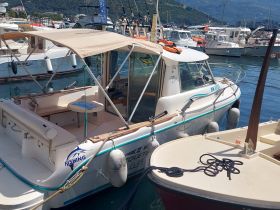 Interior view of a fishing boat showcasing the seating and cabin area, perfect for a day out on the water.