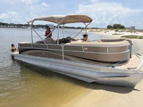 A family enjoys a sunny day at the beach with a pontoon boat, featuring kids playing in the water and adults relaxing on board — perfect for summer fun and family outings.