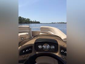 A view from the helm of a pontoon boat, showcasing the console and seating area — perfect for navigating serene waters.