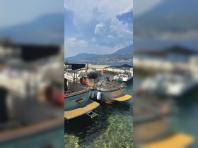 A picturesque view of two 'Barbarosa' boats docked in clear waters, set against a stunning mountainous backdrop — perfect for exploring coastal destinations.