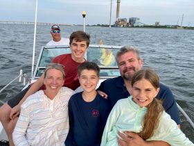 A joyful family poses together on a boat, capturing a memorable moment on the water. Perfect for showcasing family outings and fun adventures.