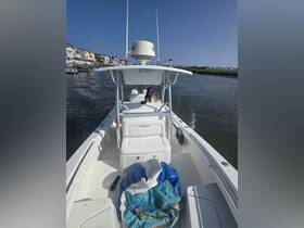A view of the interior of a Regulator boat featuring comfortable seating and a helm, with a guest enjoying the ride on a sunny day.