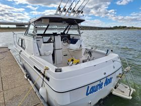 A clear view of the 'Laurie Ann' boat docked at the water's edge, showcasing its sleek design and fishing equipment, perfect for a day out on the water.
