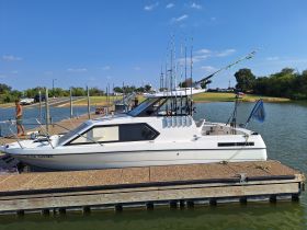 A fishing boat is docked with fishing rods ready for action, while a person prepares for a day on the water. Perfect for fishing enthusiasts looking to enjoy a day out.