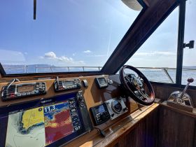 A detailed view of the helm inside a boat, showcasing navigation equipment and controls, perfect for understanding the boating experience.