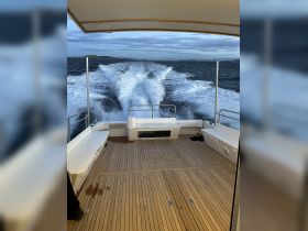 Interior view of a spacious boat deck showcasing comfortable seating and a helm, perfect for enjoying a smooth ride on the water.