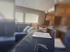 Interior view of a boat cabin featuring comfortable seating and a well-organized space, perfect for relaxing during a day on the water.