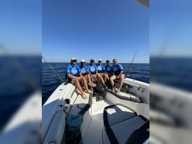 A group of friends enjoys a fishing trip on a boat, showcasing camaraderie and the thrill of ocean adventures.