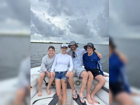 A joyful family poses together on a boat, capturing a memorable moment on the water — perfect for family outings and adventures.
