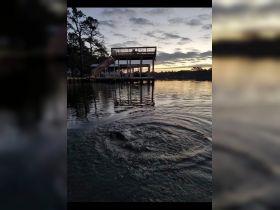 An unclear image depicting a dock and water surface, with some ripples visible. The scene lacks identifiable subjects or clarity.