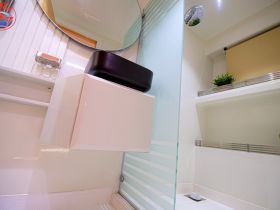 A clean and modern bathroom interior on a boat, featuring a stylish mirror and storage space, ideal for comfortable cruising.