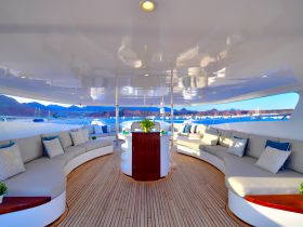 A beautifully designed lounge area inside a yacht, featuring comfortable seating and elegant decor, perfect for relaxing while enjoying scenic views.