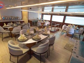 Elegant dining area inside a luxury boat, featuring beautifully set tables and modern decor, perfect for onboard dining experiences.