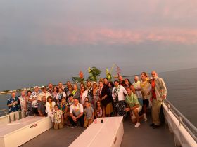 A lively group gathers on a boat for a festive celebration, showcasing a vibrant atmosphere perfect for parties and gatherings on the water.