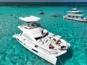 A lively group enjoys a sunny day on a catamaran, lounging and swimming in the stunning turquoise waters — a perfect setting for relaxation and fun on the water.
