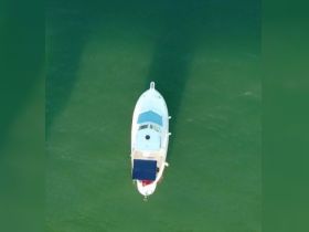 Aerial view of a sleek boat cruising through clear waters, showcasing its elegant design and perfect for a day on the water.