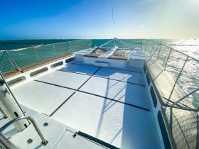 A spacious deck of a catamaran showcasing the open sea, perfect for enjoying the sun and sea breeze during a sailing adventure.