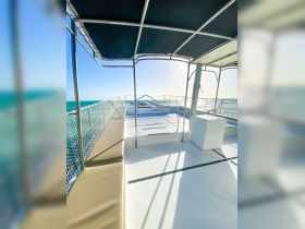A spacious interior view of a catamaran, showcasing comfortable seating and a well-designed helm area, perfect for relaxing while cruising on the water.