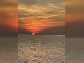 A stunning sunset over calm waters, creating a picturesque backdrop for evening boat cruises or romantic getaways.
