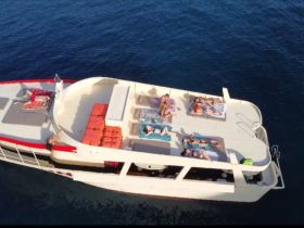 A lively group enjoys sunbathing on the deck of a boat, perfect for relaxation and fun on the water.