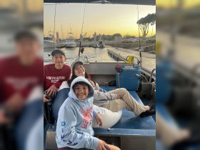 A cheerful group of kids enjoys a sunset on a boat, capturing the joy of a fun day on the water — perfect for family outings or youth adventures.