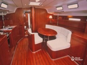 Interior view of a cozy boat cabin featuring a dining area and kitchen space, perfect for relaxing and enjoying meals while at sea.