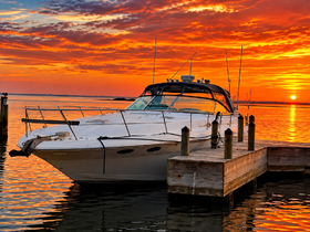 A stunning sunset view of a yacht docked at the pier, showcasing the boat's elegant design against a vibrant sky.
