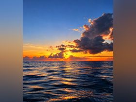 A breathtaking sunset over the ocean, with vibrant colors reflecting on the water's surface — a perfect backdrop for evening boat trips and romantic getaways.