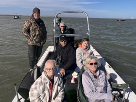 A cheerful group of friends enjoys a day on the water, showcasing camaraderie and the joy of fishing together.