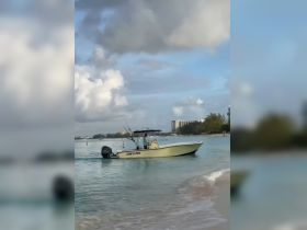 A speedboat navigates through calm waters, showcasing its sleek design and fishing gear, perfect for a day out on the water.