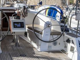 A detailed view of the helm area inside a sailboat, showcasing the navigation console and seating, perfect for those looking to explore the seas in comfort.