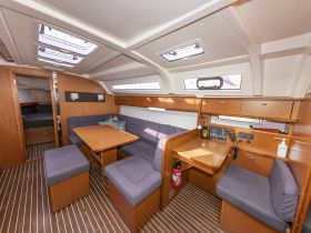 Interior view of a spacious boat cabin featuring comfortable seating and a helm area, perfect for relaxing during your nautical adventures.