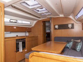 Interior view of a well-designed boat cabin featuring a cozy seating area and a functional kitchen space, perfect for relaxing and dining while on the water.