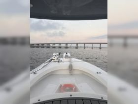A clear view from the front of a boat, showcasing the vessel's structure against a backdrop of a bridge and a serene waterway — perfect for exploring coastal landscapes.