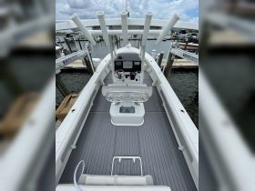 A detailed view of the helm and interior seating area of a modern boat, showcasing the sleek design and functional layout ideal for fishing or cruising.