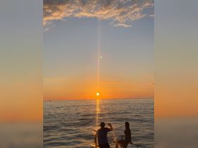 A couple enjoys a stunning sunset on the water, capturing a romantic moment aboard a boat — perfect for sunset cruises and special occasions.