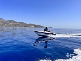 A speedboat navigates through crystal-clear waters, showcasing the stunning coastal landscape — perfect for exploring the beautiful surroundings.