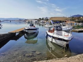 Two boats docked at a serene harbor, reflecting the calm waters and picturesque surroundings — ideal for boat rental and exploration.