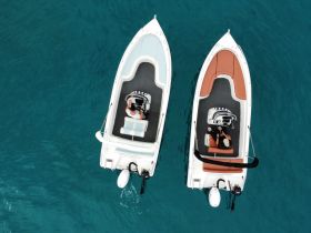 Aerial view of two boats on clear turquoise waters, showcasing a perfect day for boating adventures.