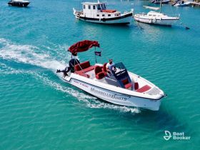 A speedboat navigates through crystal-clear turquoise waters, showcasing a perfect day for boating adventures. Ideal for exploring coastal destinations or enjoying water sports.