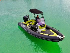 A sleek speedboat navigates through clear turquoise waters, showcasing its modern design and vibrant colors — perfect for thrilling water adventures.