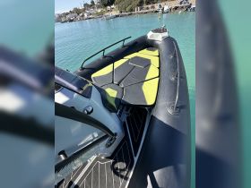 Interior view of a sleek boat featuring modern seating and console design, perfect for a comfortable day on the water.