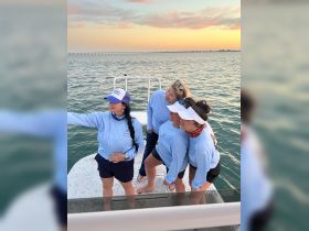 A group of friends captures a fun selfie on the deck of a boat during sunset, creating lasting memories on the water.