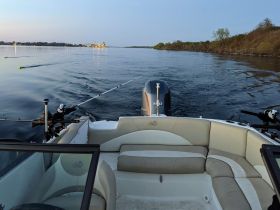 A cozy interior view of a fishing boat showcasing comfortable seating and fishing gear, perfect for a day on the water.