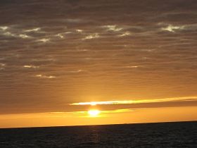 A stunning sunset over the ocean, creating a picturesque backdrop for evening boat cruises and tranquil moments on the water.