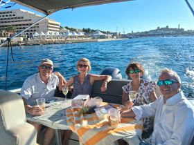 A cheerful group enjoys drinks aboard a boat, capturing the essence of a perfect day on the water with friends.